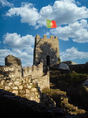 Medieval Castelo dos Mouros aka Castle of the Moors in Sintra, Portugal. Watchtower with Portuguese flag and defensive wall