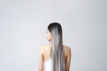 Obraz premium The rear view of a young woman with sleek, silver long hair, photographed in a studio with a white background and professional lighting. Generative AI.