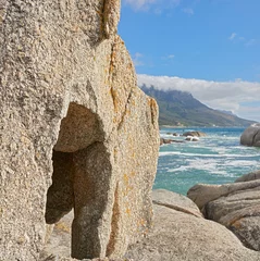 Wall murals Camps Bay Beach, Cape Town, South Africa Landscape of rocks and the ocean in Camps Bay, Cape Town, South Africa. Scenic view of big rocks on the shoreline of the beach in summer. Large stones in the sea at famous tourist destination