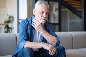 Middle aged man suffering sore throat and feeling sick