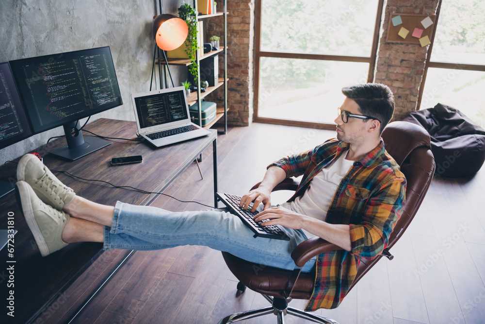 Poster full length profile photo of skilled front end developer sit chair legs desk keyboard write code scr