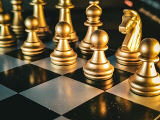 Classic wooden chess board with golden chess pieces