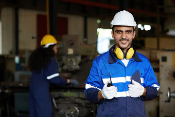 worker or engineer smiling and holding wireless radio in the factory - obrazy, fototapety, plakaty
