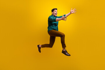 Fototapeta na wymiar Full length profile side photo of positive cheerful glad man wear trendy clothes running empty space isolated on yellow color background