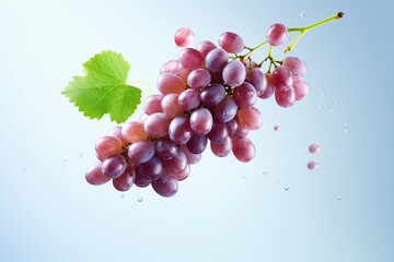 Bunch of grapes flying in the air with splashes of water on light blue background.