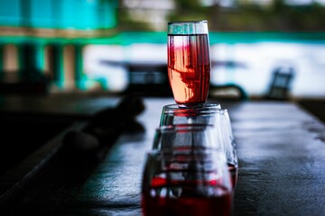 Elegant clear glass filled with liquid atop a wooden table illuminated by a beam of light