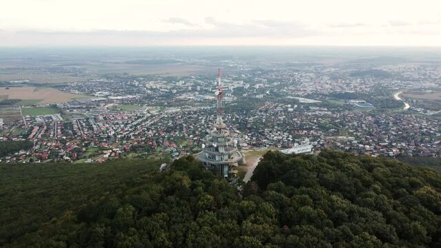 4k aerial footage of transmitter tower on Zobor Hill in Nitra - Slovakia.  Flight by drone over the hill and large city near forest.