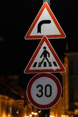 Closeup of  speed limit and pedestrian road signs with a blurry background