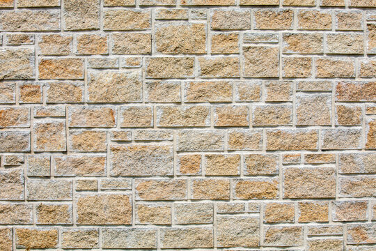 Vieux mur d'une maison en pierre apparente.