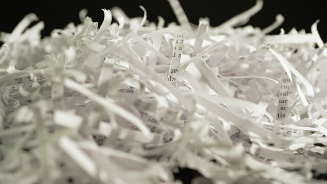 Shredded sensitive information documents with lorem ipsum text, safeguarding against unauthorized access and potential breaches. Security measure and legal compliance.