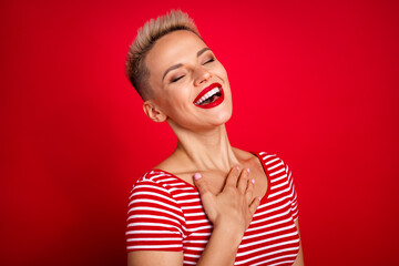 Photo of cheerful lovely girl with closed eyes laughing having fun isolated on red color background
