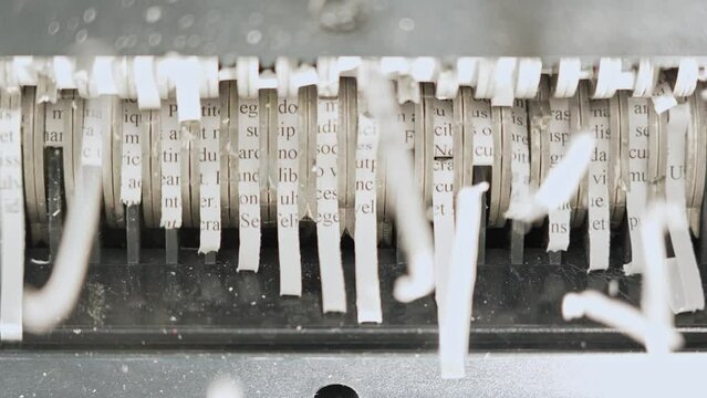 Shredded sensitive information documents with lorem ipsum text sequence footage, safeguarding against unauthorized access and potential breaches. Security measure and legal compliance.