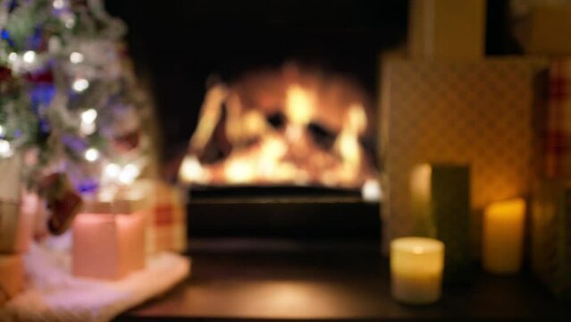 Blurry copy background with defocused Christmas atmosphere concept footage. Merry Christmas beautiful video with bright yellow glowing fireplace. Xmas tree light garland decorated, indoor interior