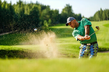 Golfer hits ball from a bunker with golf club - obrazy, fototapety, plakaty