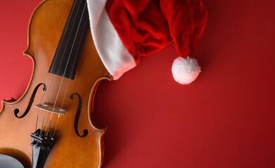 Violin body with Santa hat on a red background