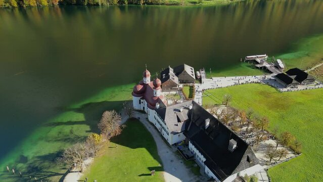 The drone aerial footage of Lake Konigsee with Sankt Bartholomae pilgrimage church and Watzmann mountain, Berchtesgadener land, Bavaria, Germany.