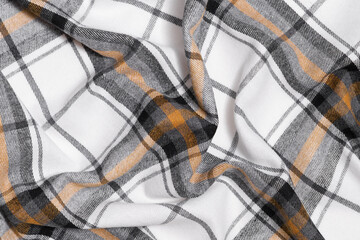 Close-up of crumpled texture of white, yellow and black tartan fabric. Image for your design. Traditional Scottish clothing.