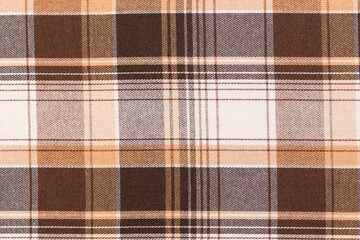 Texture of traditional Scottish tartan check fabric in brown and ivory colors. Material for making...