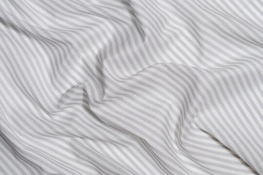 close-up texture of crumpled gray-white striped fabric. material for sewing clothes and textiles for the home, marine theme concept. Image for your design