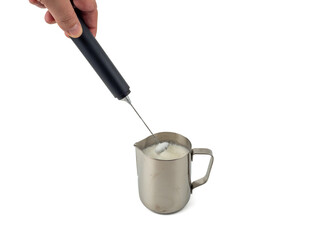 Automatic milk foam maker. Metal milk mug and electric milk frother isolated on a white background.