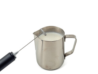 Automatic milk foam maker. Metal milk mug and electric milk frother isolated on a white background.