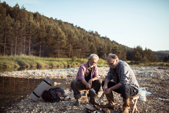 Two senior men camping in nature