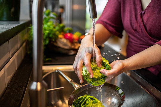 Close up of woman washing vegetables in the sink