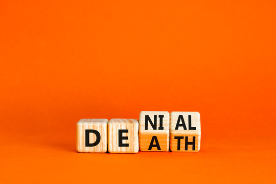 Denial death symbol. Concept words Denial Death on wooden block. Beautiful orange table orange background. Business denial death concept. Copy space.