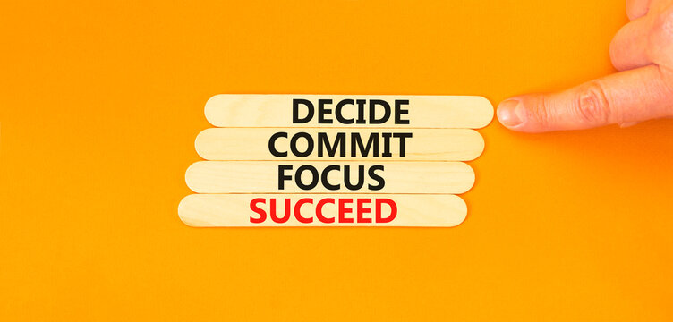 Decide commit focus succeed symbol. Concept word Decide Commit Focus Succeed on beautiful wooden stick. Beautiful orange background. Business decide commit focus succeed concept. Copy space.