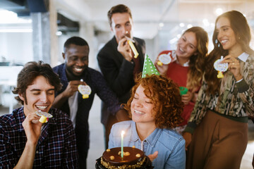 Young businesspeople celebrating their colleagues birthday in office