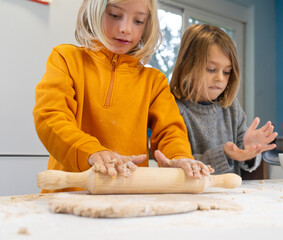 Two brothers kneading dough to make pizza at home