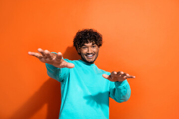 Portrait of overjoyed cheerful person have good mood arms dancing chilling isolated on orange color background