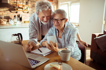 Senior couple using a smartphone together at home