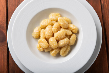  Primo piano di gnocchi di patate conditi con burro e formaggio, cibo italiano 