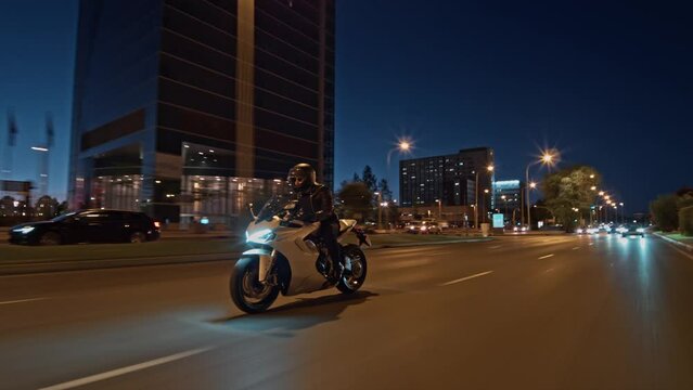 Rolling shot follow crane of man riding supersport motorcycle on the street of Madrid at night