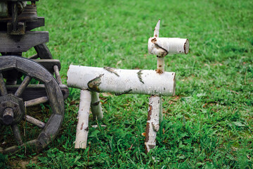 A figurine of a farm animal and birch logs near a cart, a statuette