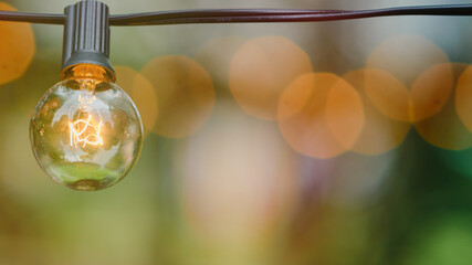 An electric lamp shines brightly against the lush green background of nature. © Андрей Журавлев