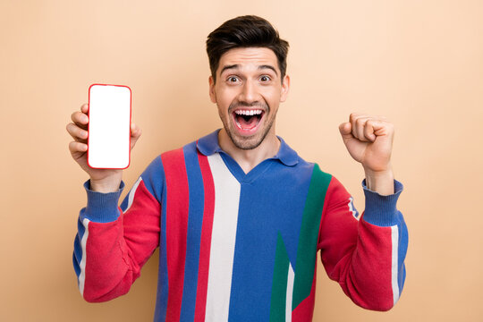 Photo of cool advertisement young guy celebrating mega sale black friday on phone display free coupon isolated on beige color background