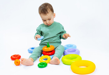 Fototapeta na wymiar Adorable Baby Engaged in Playtime Fun. A baby sitting on the ground playing with toys