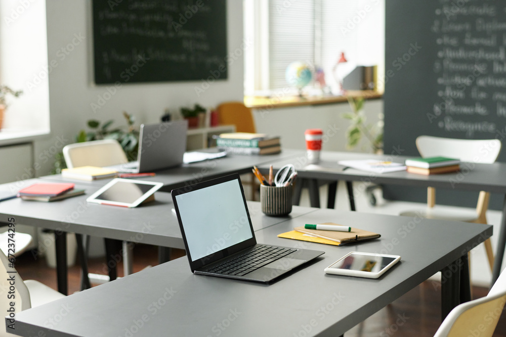 Wall mural laptop for online work on desk in empty classroom at school