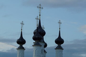 Obraz premium Multiple pointed-roof buildings featuring spires silhouetted against a cloudy sky