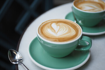 a cup of late coffee with flower shape design on top at cafe 