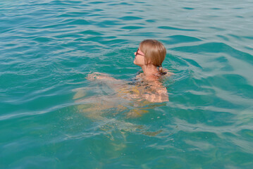 Fototapeta na wymiar Teenage girl is in the water enjoying a sea holiday