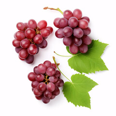 A top view of isolated, halved red grapes with verdant leaves on a white backdrop.