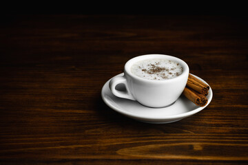 Cup of Cappucino Italian Coffee with Cinnamon Sticks. Copy Space