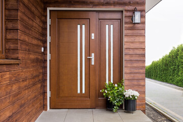 Designer entrance door to a country house. Modern design. luxurious exterior. Facade of a modern building with modern door 