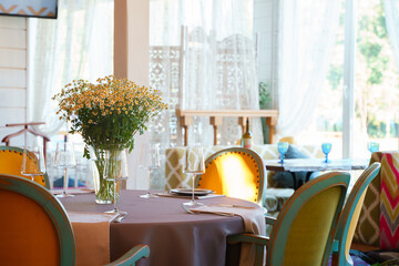 A bouquet of daisies on the table, a beautiful interior with a table and chairs
