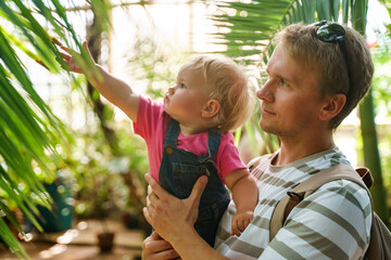 A little girl kid with her father in the Botanical Garden in St. Petersburg