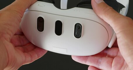Hands holding new white VR glasses with three cameras. Mixed reality headset.
