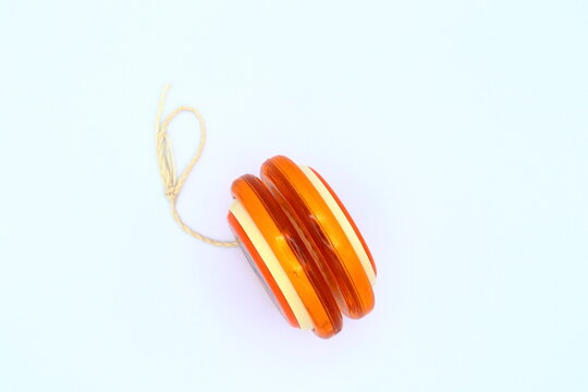 Orange yoyo from the side. White background.